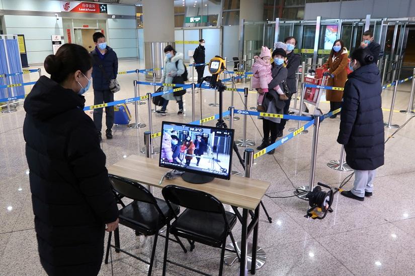 Staff members monitor thermal scanners that detect temperatures of passengers who have just landed, at the arrival terminal in Beijing Capital International Airport in Beijing, China Jan 25, 2020. REUTERS