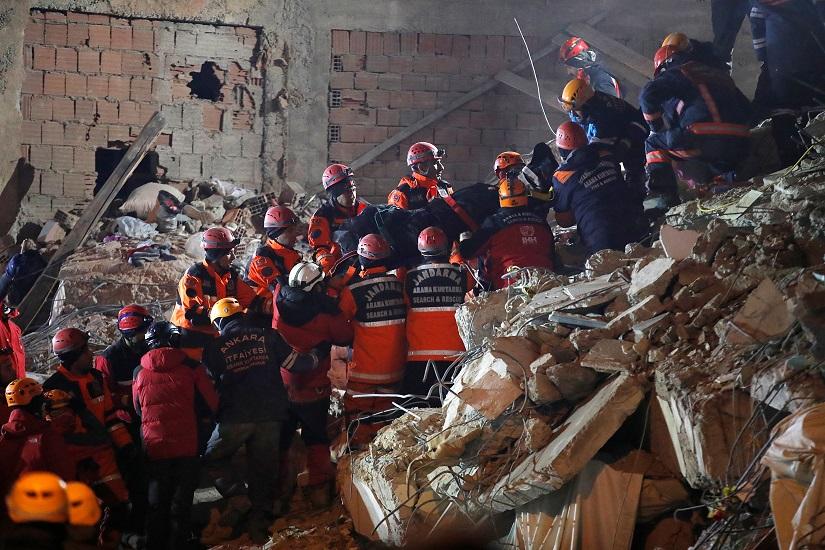 Rescue workers carry a body from the site of a collapsed building after an earthquake in Elazig, Turkey, Jan 26, 2020. REUTERS