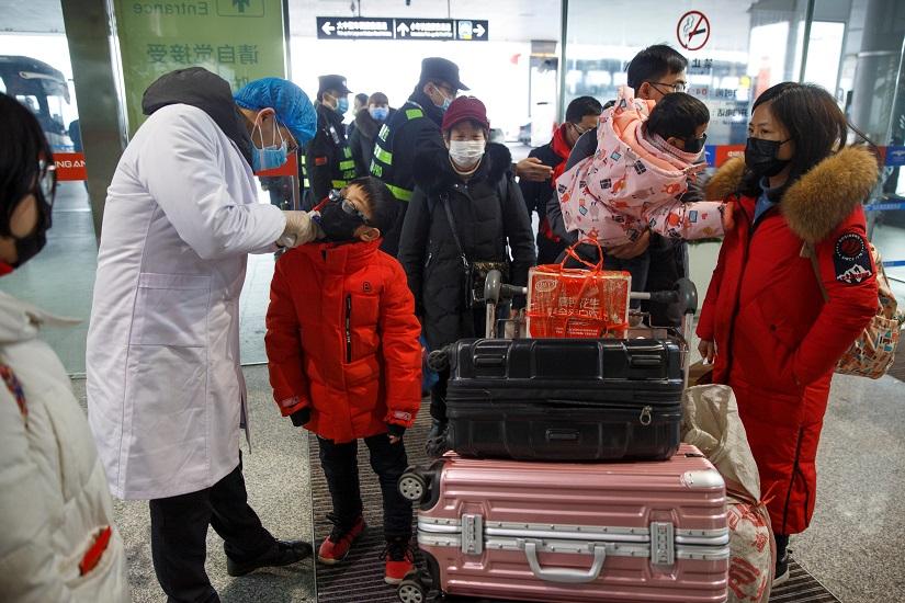 A medical official takes the body temperature of a child at the departure hall of the airport in Changsha, Hunan Province, as the country is hit by an outbreak of a new coronavirus, China, Jan 27, 2020. REUTERS