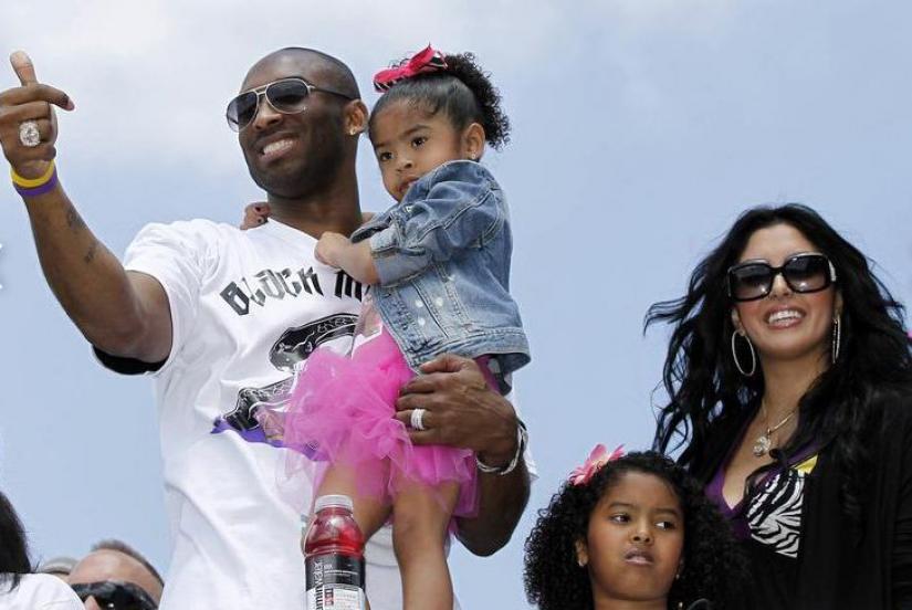 FILE PHOTO: Kobe Bryant carries his daughter Gianna, as his wife Vanessa and daughter Natalia (2nd R) stand next to him during the Lakers` NBA Championship parade in Los Angeles, California, Jun 21, 2010. REUTERS