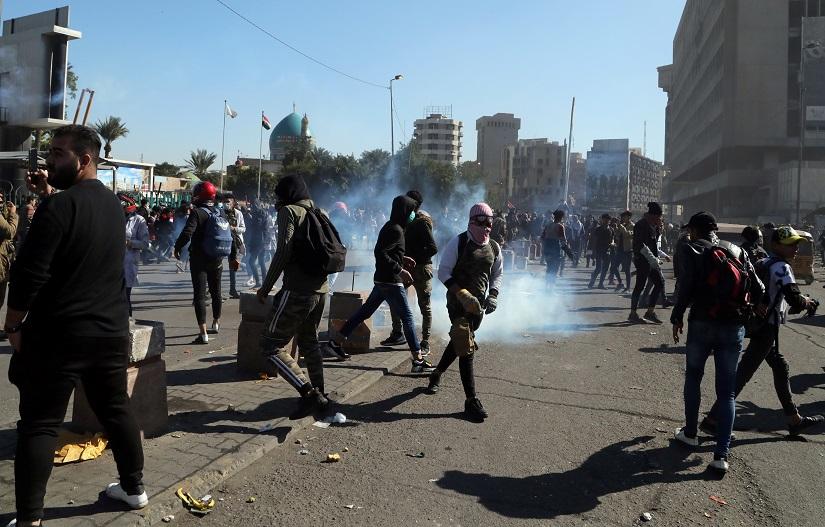 Iraqi demonstrators walk among tear gas during ongoing anti-government protests in Baghdad, Iraq Jan 27, 2020. REUTERS