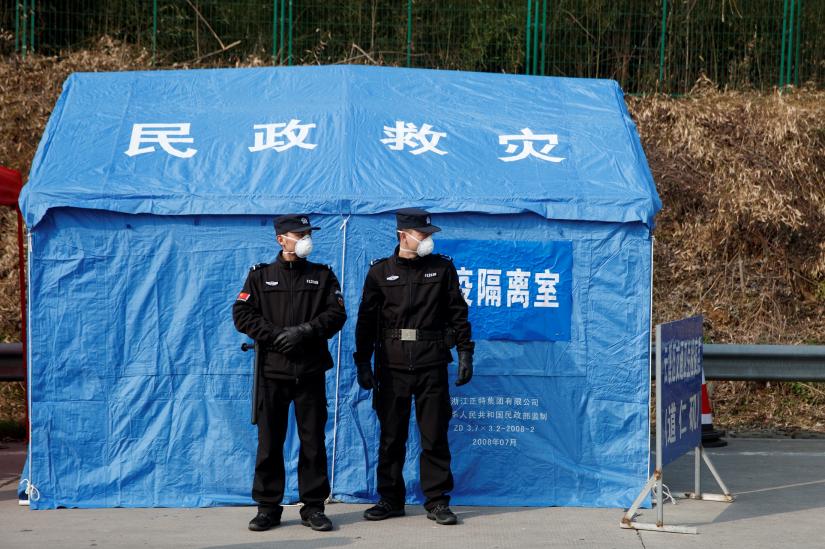 Security personnel stand in front of a disaster relief tent at a checkpoint in Yunxi county, Hunan province, near the border to Hubei province, on virtual lockdown after an outbreak of a new coronavirus, in China, January 28, 2020. REUTERS