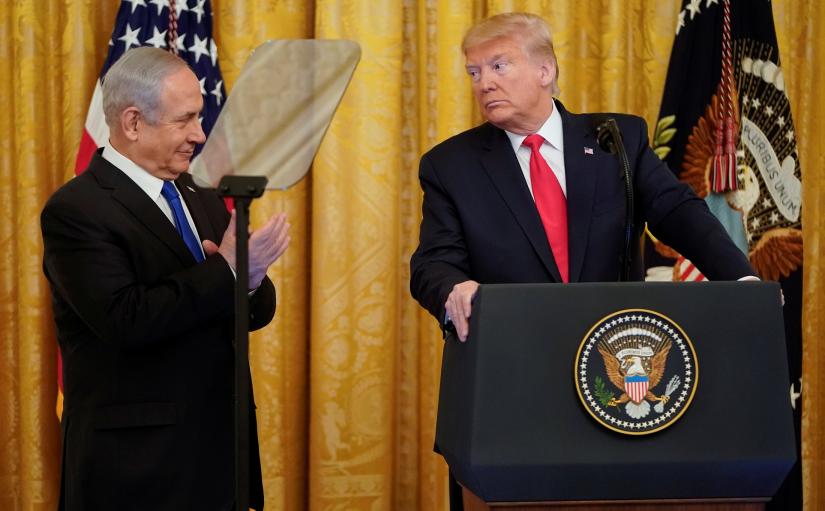 U.S. President Donald Trump looks over at Israel`s Prime Minister Benjamin Netanyahu during a joint news conference to announce a new Middle East peace plan proposal in the East Room of the White House in Washington, U.S., January 28, 2020. REUTERS