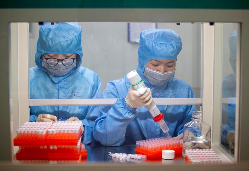 Workers in protective suits work at the production line manufacturing detection kits for the new coronavirus at a company, as the country is hit by an outbreak of the new coronavirus, in Taizhou, Jiangsu province, China Jan 29, 2020. cnsphoto via REUTERS.
