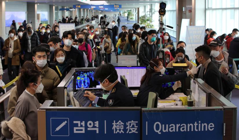Passengers from China wearing masks to prevent a new coronavirus get fever check upon their arrival at Incheon International Airport in Incheon, South Korea, January 29, 2020 Yonhap via REUTERS