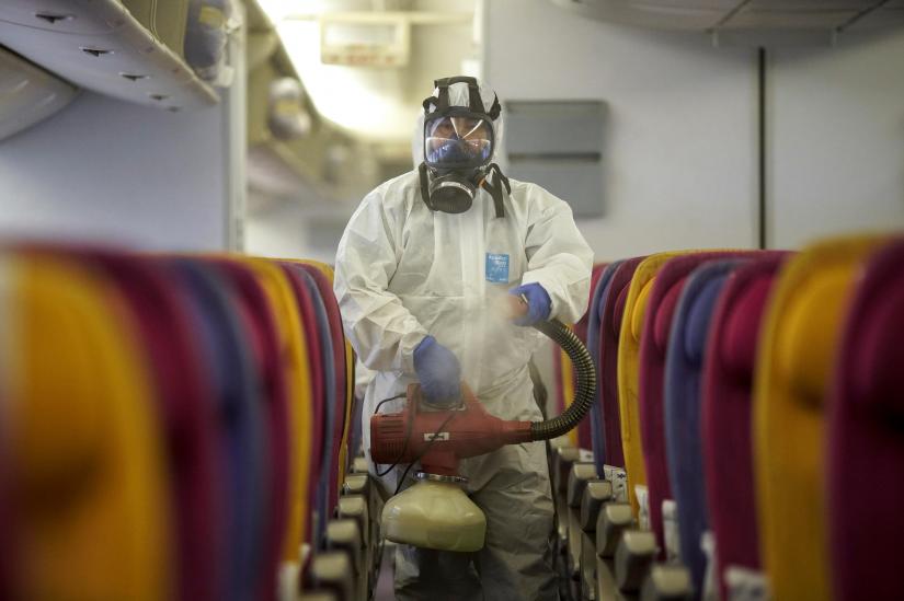 A member of the Thai Airways crew disinfects the cabin of an aircraft of the national carrier during a procedure to prevent the spread of the coronavirus at Bangkok`s Suvarnabhumi International Airport, Thailand, January 28, 2020. REUTERS/File Photo