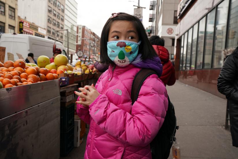 A young resident of Chinatown wears a surgical mask in New York City, U.S., January 31, 2020. REUTERS