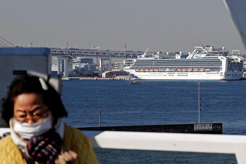A woman wearing a mask turns around after viewing the cruise ship Diamond Princess, where dozens of passengers were tested positive for coronavirus, from an observation deck overlooking the Daikoku Pier Cruise Terminal in Yokohama, south of Tokyo, Japan Feb 10, 2020. REUTERS