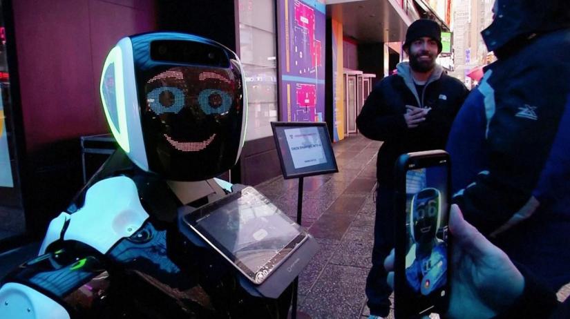 Passers-by in Times Square interact with a Promobot robot that informs the public about the symptoms of coronavirus and how to prevent it from spreading, in this still frame obtained from video, in New York City, US Feb 10, 2020. REUTERS/Reuters TV