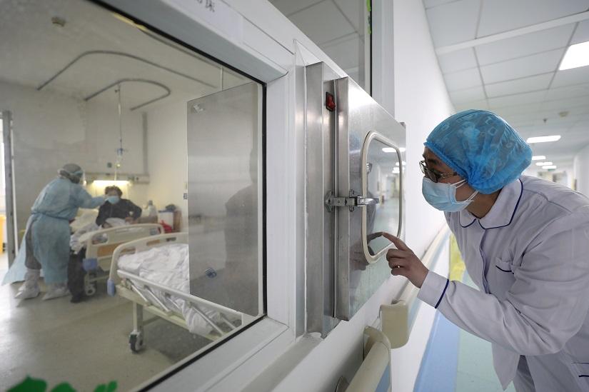 A medical worker calls his colleague inside an isolated ward at Jinyintan Hospital in Wuhan, the epicentre of the novel coronavirus outbreak, in Hubei province, China Feb 13, 2020. China Daily via REUTERS