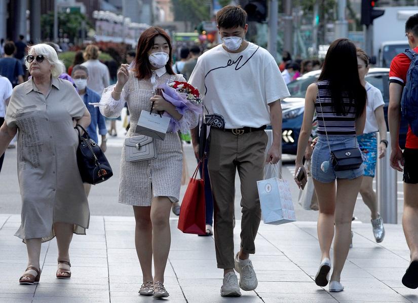 A couple celebrate Valentine`s Day as they wear face masks in precaution of the coronavirus outbreak at Orchard Road in Singapore Feb 14, 2020. REUTERS
