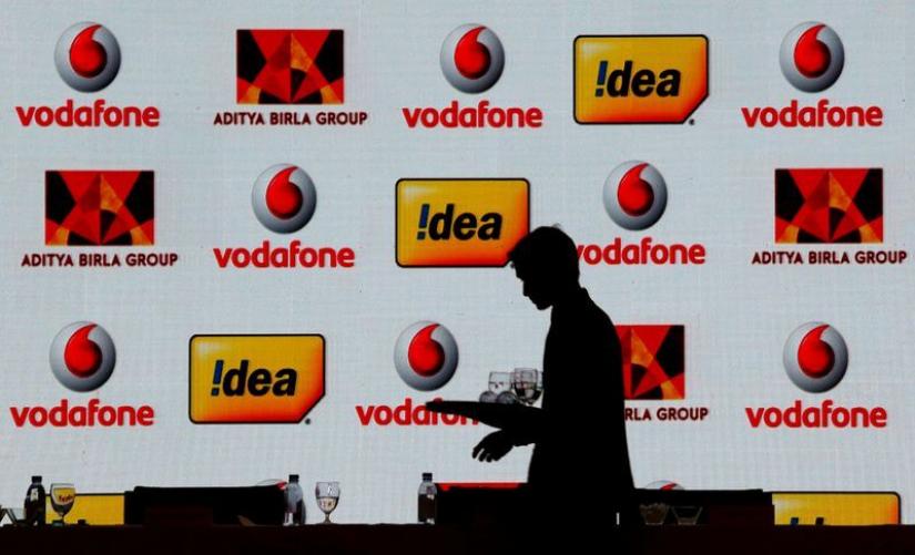 FILE PHOTO: A hotel employee clears a table after Vodafone Group and Idea Cellular news conference in Mumbai, India Mar 20, 2017. REUTERS