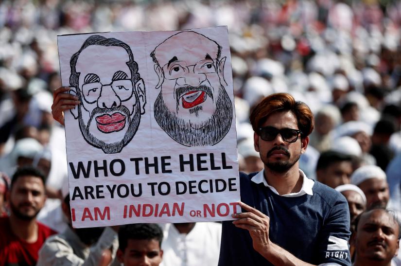 A man holds a poster during a protest against a new citizenship law in Mumbai, India February 15, 2020. REUTERS