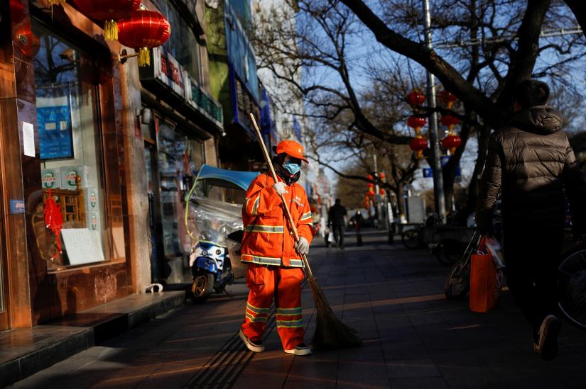 A street cleaner wearing a face mask works along a sidewalk, as the country is hit by an outbreak of the new coronavirus, in Beijing, China February 18, 2020. REUTERS