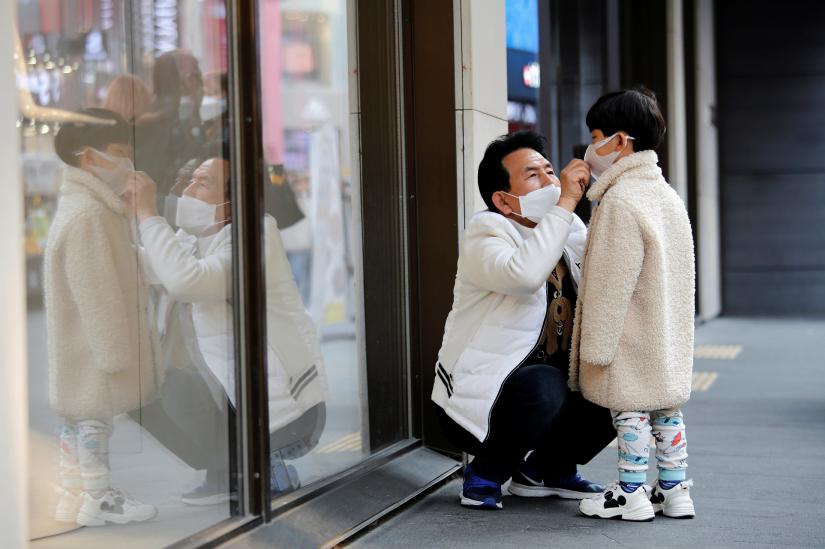 A man and a boy wear masks to prevent contracting a new coronavirus at Myeongdong shopping district in Seoul, South Korea, February 20, 2020. REUTERS