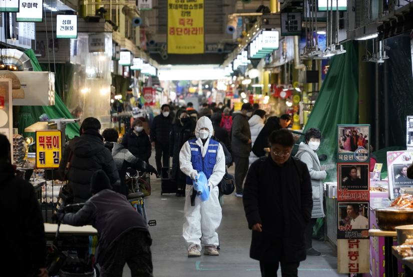 An employee from a disinfection service company sanitizes the floor of a traditional market in Seoul, South Korea, February 24, 2020. REUTERS
