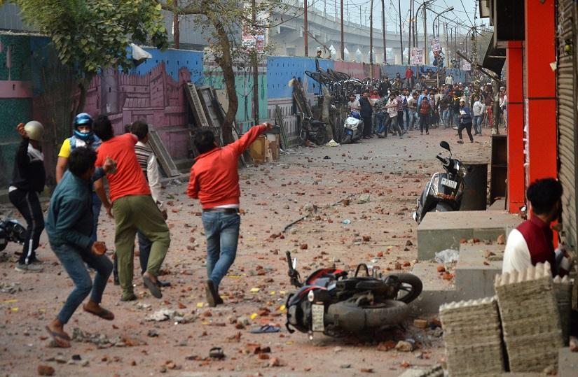 People supporting a new citizenship law and those opposing the law, throw stones at each other during a clash in Maujpur area of New Delhi, India, Feb 23, 2020. REUTERS