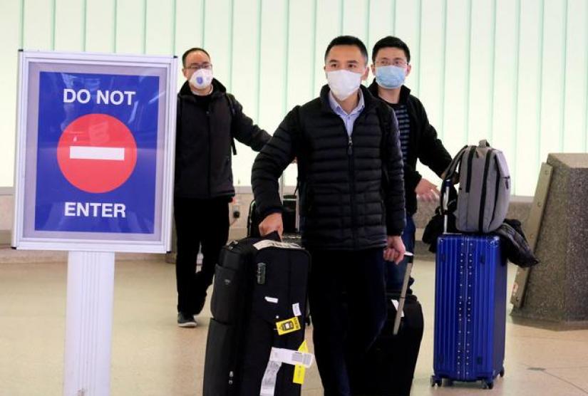 FILE PHOTO: Passengers arrive at LAX from Shanghai, China, after a positive case of the coronavirus was announced in the Orange County suburb of Los Angeles, California, US, Jan 26, 2020. REUTERS