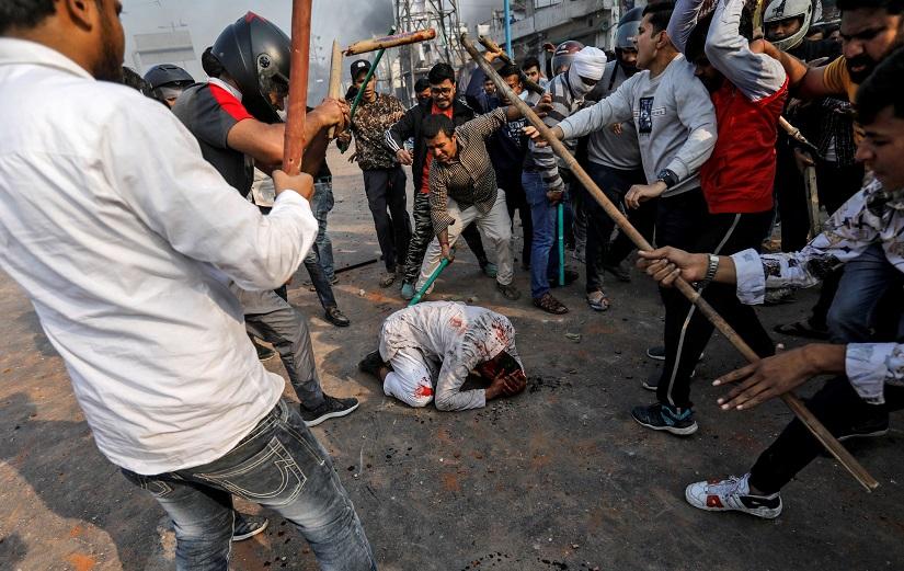 People supporting the new citizenship law beat a Muslim man during a clash with those opposing the law in New Delhi, India, Feb 24, 2020. REUTERS