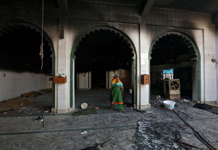 A woman walks inside a partially damaged mosque after it was set on fire by a mob in a riot affected area after clashes erupted between people demonstrating for and against a new citizenship law in New Delhi, India, February 26, 2020. REUTERS