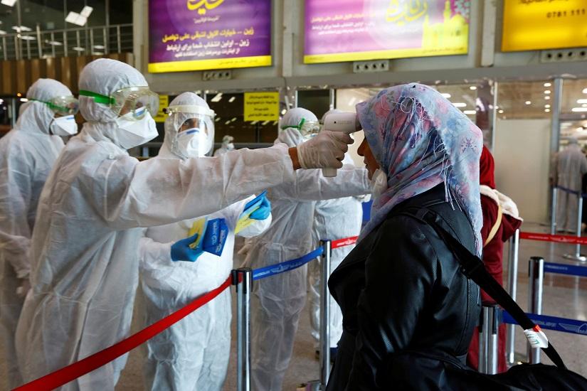 Iraqi medical staff check passengers` temperature, amid coronavirus outbreak, upon their arrival from Iran, at Najaf airport, Iraq Mar 5, 2020. REUTERS
