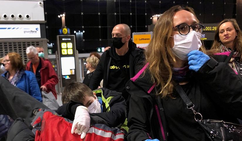 People wait for their flight as they wear protective mask against coronavirus (COVID-19) at the airport in Malaga, Spain Mar 17, 2020. REUTERS
