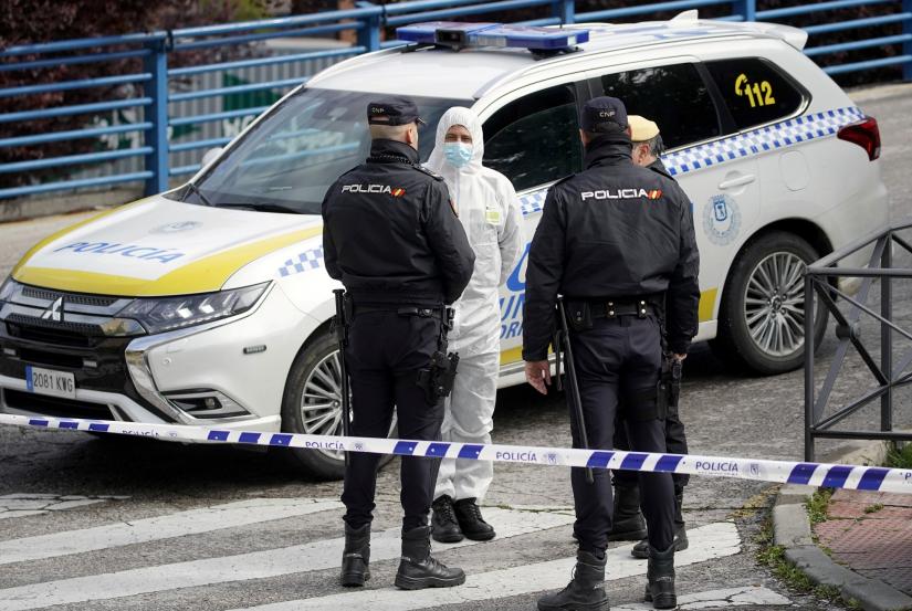 A member of the Spanish army talks with Spanish National policemen outside an ice rink which will be used as a morgue, during the coronavirus disease (COVID-19) outbreak in Madrid, Spain, March 24, 2020. REUTERS