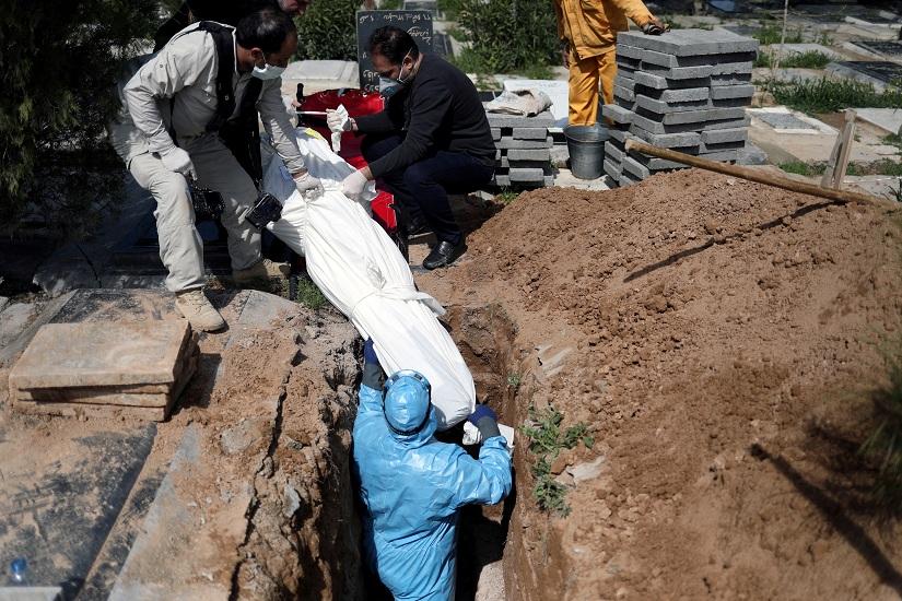 Iranian men bury the journalist Abdollah Zavieh, who passed away due to coronavirus disease (COVID-19), at Behesht Zahra cemetery in Tehran, Iran, Mar 24, 2020. WANA (West Asia News Agency)/Ali Khara via REUTERS