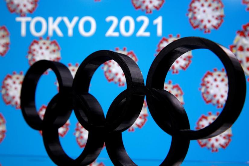 A 3D printed Olympics logo is seen in front of displayed `Tokyo 2021` words in this illustration taken Mar 24, 2020. REUTERS
