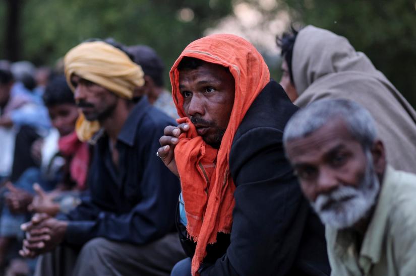Daily wage workers and homeless people wait for food outside a government-run night shelter during a 21-day nationwide lockdown to limit the spreading of coronavirus disease (COVID-19), in New Delhi, India, March 25, 2020. REUTERS
