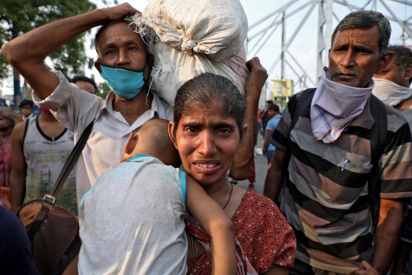 A migrant worker holding her baby cries after she missed out on receiving free food outside Howrah railway station after India ordered a 21-day nationwide lockdown to limit the spreading of coronavirus disease (COVID-19), in Kolkata, India, March 25, 2020. REUTERS