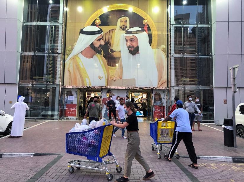 People are seen in front of supermarket, following the outbreak of the coronavirus disease (COVID-19), in Dubai, United Arab Emirates, March 26, 2020. REUTERS
