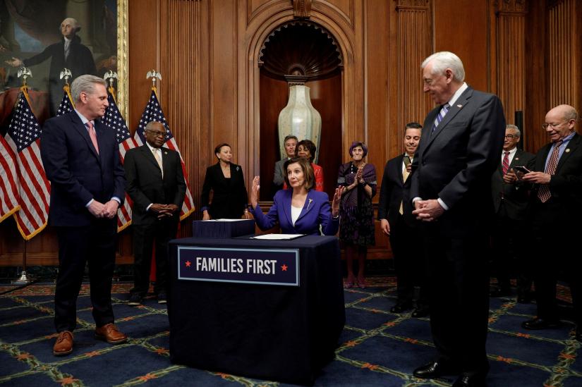 U.S. House Speaker Nancy Pelosi (D-CA) is flanked by House Minority Leader Kevin McCarthy (R-CA) and Majority Leader Steny Hoyer (D-MD) as she speaks during a signing ceremony after the House of Representatives approved a $2.2 trillion coronavirus aid package at the U.S. Capitol in Washington, U.S., March 27, 2020. REUTERS
