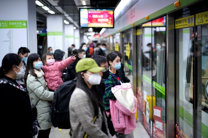 People wearing face masks wait for a subway train on the first day the city`s subway services resumed following the novel coronavirus disease (COVID-19) outbreak, in Wuhan of Hubei province, the epicentre of China`s coronavirus outbreak, March 28, 2020. The Chinese characters REUTERS/