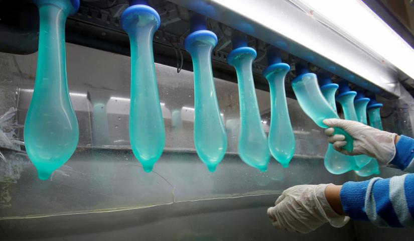 FILE PHOTO: A worker performs a test on condoms at Malaysia`s Karex condom factory in Pontian, 320 km (200 miles) southeast of Kuala Lumpur November 7, 2012. Malaysia`s Karex Industries is the world`s largest condom maker by volume. Picture taken November 7, 2012. REUTERS