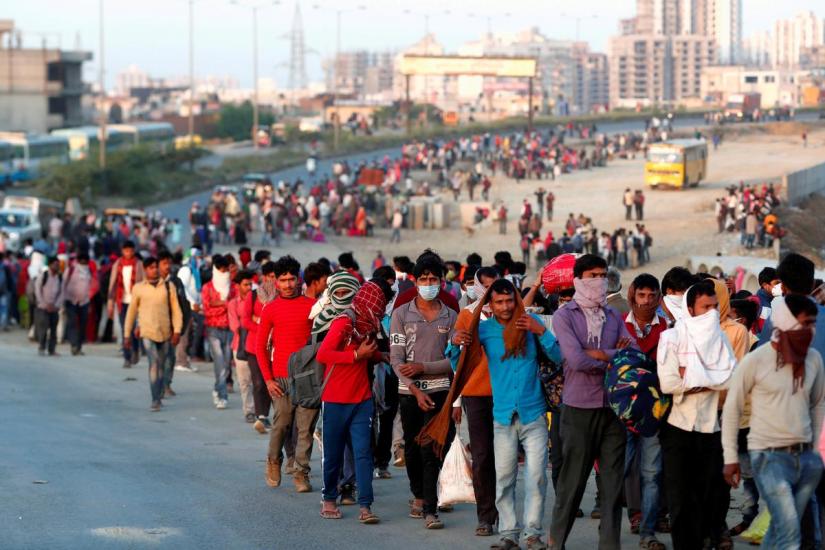 Migrant workers walk towards a bus station along a highway with their families as they return to their villages, during a 21-day nationwide lockdown to limit the spreading of coronavirus disease (COVID-19), in Ghaziabad, on the outskirts of New Delhi, Mar 29, 2020. REUTERS
