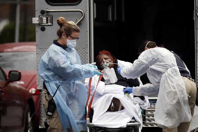 Emergency Medical Technicians (EMT) wearing protective gears wheel a sick patient to a waiting ambulance during the outbreak of coronavirus disease (COVID-19) in New York City, New York, US, March 28, 2020. REUTERS