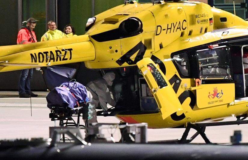 A patient from Bergamo lies on a stretcher next to a medical helicopter upon arrival with a German Bundeswehr air force Airbus A-310 `Medivac` at Helmut-Schmidt-Airport, as the spread of the coronavirus disease (COVID-19) continues, in Hamburg, Germany Mar 29, 2020. REUTERS
